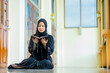 © maya1313 - Ramadan, The image of an Asian Muslim woman in the Islamic religion in hijab in black color. reading the Quran and having a happy smiling face Staying in a beautiful mosque out of respect for God.