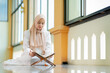 © maya1313 - Ramadan, quran, The image of an Asian Muslim woman in the Islamic religion in hijab in cream color. reading the Quran and having a happy Staying in a beautiful mosque, Arabic word Holy Al Quran.