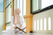 © maya1313 - Ramadan, quran, The image of an Asian Muslim woman in the Islamic religion in hijab in cream color. reading the Quran and having a happy Staying in a beautiful mosque, Arabic word Holy Al Quran.