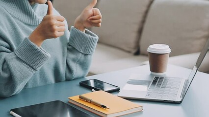 Wall Mural - Woman hand holding white mobile phone on a table with a laptop in office.