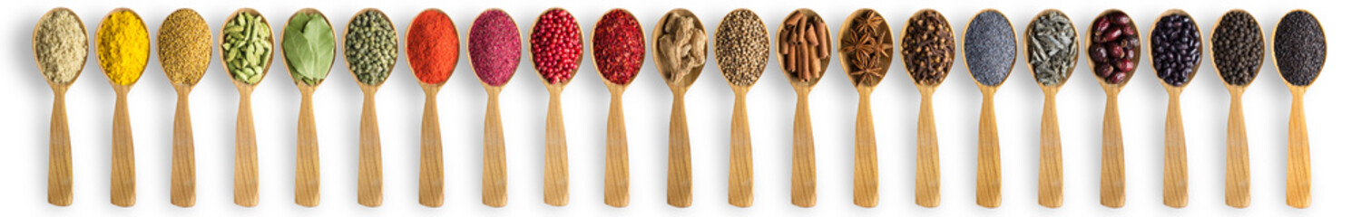 Wall Mural - spices and herbs in wooden spoons on white table. Indian seasonings for cooking delicious food.