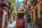 Fototapeta Uliczki - Young traveler girl explores the charming streets of an old town in Spain, embodying the spirit of solo adventure and cultural exploration.