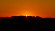 Arizona sunrise with mountains in silhouette and sun rising