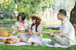 © PRIME STOCK LAB - Cheerful Asian family of three having fun together at summer picnic outdoors in the park.