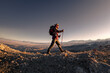 © cppzone - Hiker man with backpack walks high in mountains at sunset