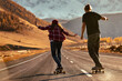 © cppzone - Young couple hipsters are training to ride on longboards at sunset mountain road