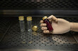 A bottle of blood specimen in a wooden mannequin hand, with decoration of a few empty glass bottles, on perforated stainless steel table. A forensic science concept photo.