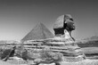 full profile of the Great Sphinx with the pyramid in the background in Giza.