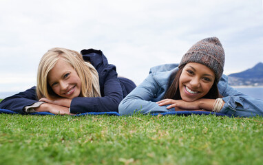 Wall Mural - Picnic, grass and portrait of women relax in field with smile, happy and relax on weekend outdoors. Friends, countryside and people in meadow for bonding on holiday, vacation and adventure in nature