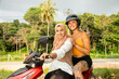 © Connect Images - Portrait of two young female friends one wearing a hijab, stop their moped to look the coastal view