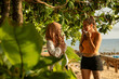 © Connect Images - Two young women friends , one wearing hijab, walk along the coastal path in southern Thailand