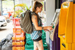 © Connect Images - young female solo traveller takes out cash from the ATM