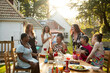 © Image Source - A mixed gathering of women laughing and having fun at a summer garden birthday party celebration lunch