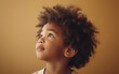 © imagineRbc - A multiracial little girl with curly hair looks up, showcasing her natural beauty and curious expression.