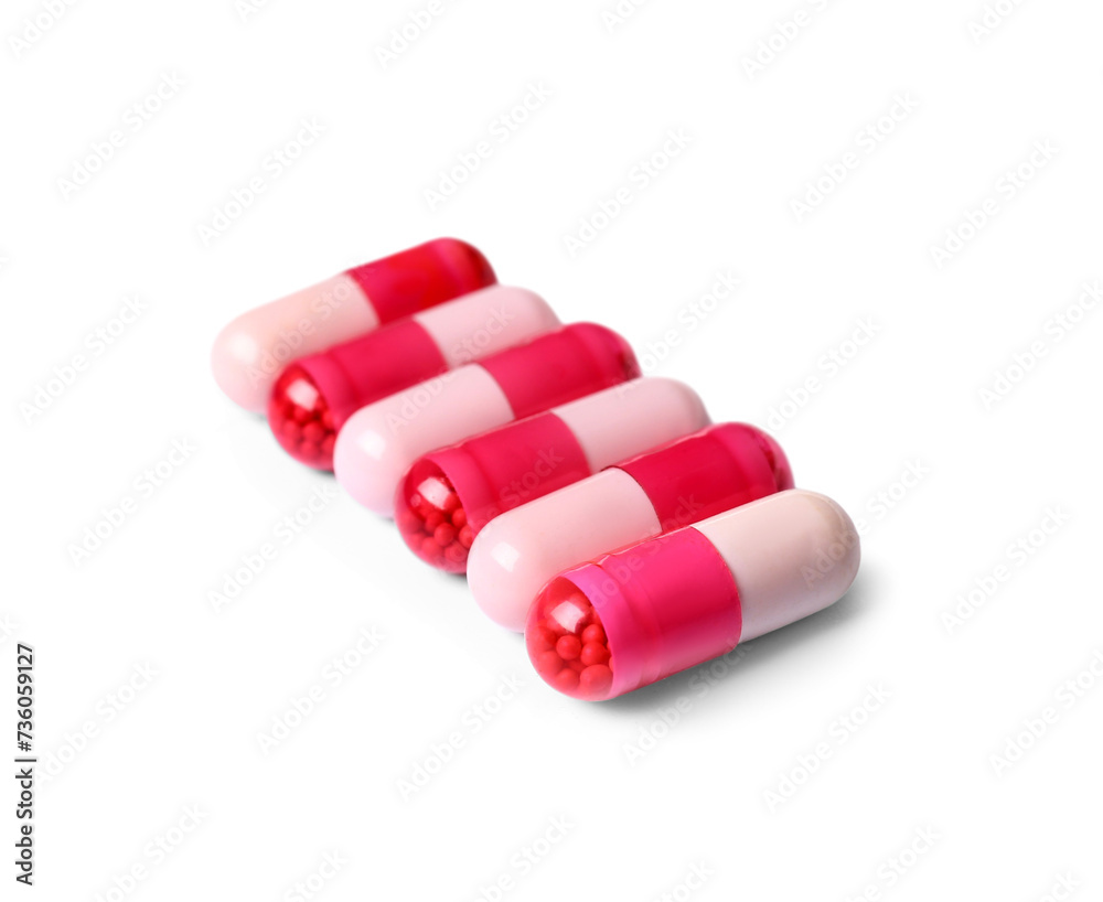 Pink pills on white background