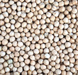 Crop of many dry round chickpea grains on flat surface as background top view closeup