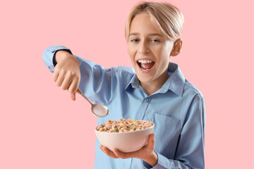 Sticker - Happy little boy eating cereal rings on pink background