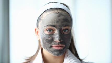 Wall Mural - Close-up view of young beautiful woman wearing cleaning face mask. Lovely girl after bath. Skincare treatment. Wellness and beauty procedure at home concept