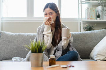 Wall Mural - Seasonal sick concept. the young woman has a common cold and sneezing on the sofa.