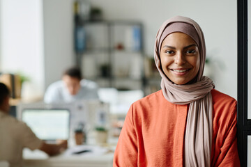 Aufkleber - Happy young Muslim female entrepreneur or manager in hijab looking at camera with smile while standing in coworking space