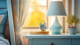 Fototapeta Paryż - Pastel blue nightstand with lamp and a stack of pastel-covered journals