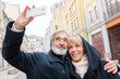 © luengo_ua - Loving mature caucasian couple taking selfie by mobile phone on city street