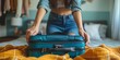 Young lady packing luggage on bed.