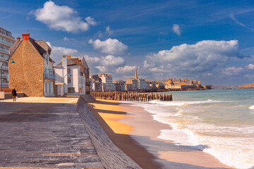 Wall Mural - Sunny promenade and beach of beautiful walled port city of Saint-Malo at high tide, Brittany, France