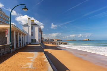 Wall Mural - Sunny promenade and beach of beautiful walled port city of Saint-Malo at high tide, Brittany, France