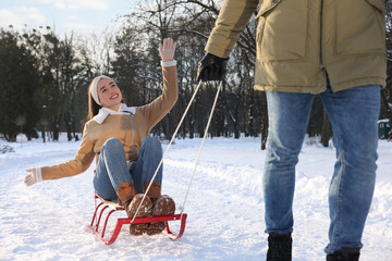 Poster - Man pulling his girlfriend in sleigh outdoors on winter day