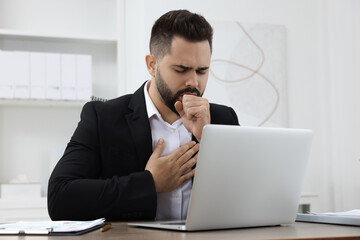 Wall Mural - Sick man coughing at workplace in office