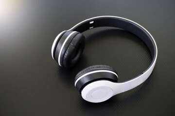 White wireless Bluetooth headphones on black background. The highlight of wireless Bluetooth headphones is No connector There is no connecting cable between the left and right headphones.