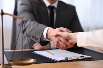 Wall Mural - Notary shaking hands with client at wooden table in office, closeup