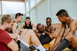 © Marko Geber - Young people taking a break from playing basketball in an indoor basketball gym