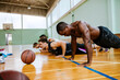© Marko Geber - Young people taking a break from playing basketball in an indoor basketball gym