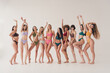 Full length photo of ten best models body positive girls relaxed dancing raised hands up at white studio background