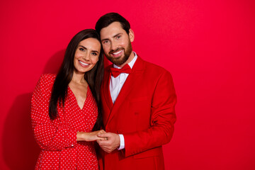 Sticker - Photo portrait of lovely young couple hold hands care valentine day dressed stylish elegant outfit isolated on red color background