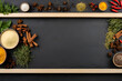 Top view of a black slate background with all sorts of spices for cooking and seasoning placed