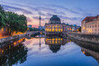 Historical buildings on Museum Island in Berlin in the morning at sunrise. River Spree with reflections. Television tower in the background of the skyline of the capital of Germany