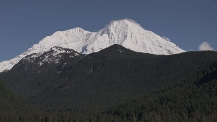 Wall Mural - Ungraded aerial drone footage of Mount Rainier covered by fresh, brilliant white snow on a bright, sunny winter morning in Washington State.