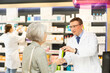 © JackF - Polite middle-aged male pharmacist consulting old woman costumer about care product in box in chemist's shop