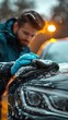 © FryArt - A man thoroughly cleaning a car in the snowy weather using a microfiber cloth.