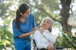 © Phushutter - Compassionate Asian woman provides care to  elderly person in wheelchair outdoors. Engaging in physical therapy, happiness, encouraging positive environment for mature individuals with grey hair.