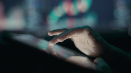 Person analyzing stocks using graphs and charts on a tablet app. Close up, slow motion. 