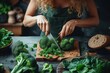 Woman in a green apron precisely cutting fresh broccoli on a wooden board at a kitchen counter