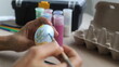 © Victor Photo Stock - hands of a dark-skinned Latina artisan woman, painting Easter eggs with brushes and acrylic paints