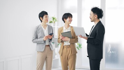 Aufkleber - パソコンを見ながら話すビジネスパーソンのグループ