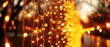 a close - up of a string of lights hanging from a tree with a blurry background of trees in the background.