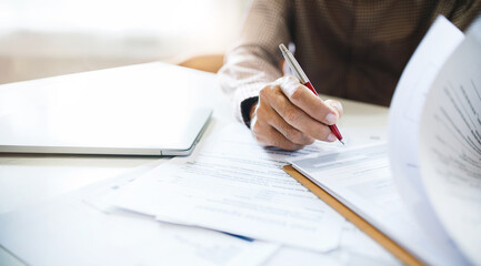 Wall Mural - Asian businessman reviewing document reports at office workplace, legal expert, professional lawyer reading and checking financial documents or insurance contract before sign, close-up shot