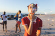 Young Caucasian woman blows bubbles on a sunny beach